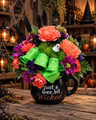 Spellbound Spirits Halloween flower arrangement with coral, purple and green blooms, bright green bow and playful ghost accent in a black “Just a Wee Bit Wicked” keepsake mug.